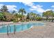 Outdoor pool featuring lounge chairs, palm trees, and a stone-tiled deck, perfect for relaxation and recreation at 5819 Covington Cove Way, Orlando, FL 32829
