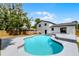 Backyard features a refreshing pool, the back of the home, and mature landscaping at 608 Pearl Rd, Winter Springs, FL 32708