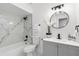 Modern bathroom featuring marble tile, updated fixtures, and a stylish round mirror at 608 Pearl Rd, Winter Springs, FL 32708