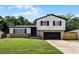 Charming two-story home with stone accents, a well-manicured lawn, and a black garage door at 608 Pearl Rd, Winter Springs, FL 32708