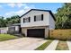 Well-maintained two-story home showcasing stone accents, black shutters, and a black garage door at 608 Pearl Rd, Winter Springs, FL 32708