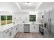 Bright kitchen featuring stainless steel appliances, sleek white cabinets, and a breakfast bar at 608 Pearl Rd, Winter Springs, FL 32708