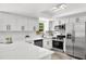 Modern kitchen with stainless steel appliances, white cabinets, and quartz countertops at 608 Pearl Rd, Winter Springs, FL 32708