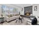 Cozy living room featuring a stone fireplace, large windows, and comfortable furnishings at 608 Pearl Rd, Winter Springs, FL 32708