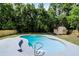 Swimming pool surrounded by a well-manicured lawn and mature trees at 608 Pearl Rd, Winter Springs, FL 32708
