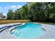 Swimming pool surrounded by a well-manicured lawn and a tall wooden privacy fence at 608 Pearl Rd, Winter Springs, FL 32708