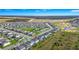 An aerial view showcases an expansive neighborhood with lush green spaces at 609 Big Pine Ave, Minneola, FL 34715