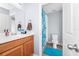 Well-lit bathroom featuring a vanity with modern fixtures and a shower with bright, patterned curtains at 609 Big Pine Ave, Minneola, FL 34715