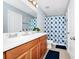 Well-lit bathroom features a dual sink vanity, a floral shower curtain, and modern fixtures at 609 Big Pine Ave, Minneola, FL 34715