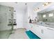 Modern bathroom with granite countertops, dual sinks, white cabinets and a walk-in shower with tiled surround at 609 Big Pine Ave, Minneola, FL 34715