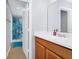 Bright bathroom featuring a vanity with modern fixtures and a shower with blue curtains at 609 Big Pine Ave, Minneola, FL 34715