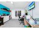 Bright room showcasing a work space, television, blue accent wall, and decorative storage on shelving at 609 Big Pine Ave, Minneola, FL 34715
