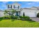 Charming two-story home featuring lush landscaping, brick driveway and two car garage at 609 Big Pine Ave, Minneola, FL 34715