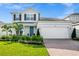 Charming two-story home featuring lush landscaping, brick driveway and two car garage at 609 Big Pine Ave, Minneola, FL 34715