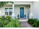 Charming entrance with blue front door, decorative plants and covered porch at 609 Big Pine Ave, Minneola, FL 34715