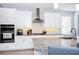 Bright kitchen features granite countertops, stainless steel appliances, and ample white cabinetry at 609 Big Pine Ave, Minneola, FL 34715