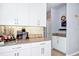 Bright kitchen featuring white cabinetry, granite countertops, and a coffee station with stylish backsplash at 609 Big Pine Ave, Minneola, FL 34715
