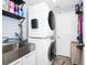 Well-lit laundry room features stacked washer/dryer, utility sink, and storage solutions at 609 Big Pine Ave, Minneola, FL 34715
