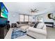 Spacious living room with a large sectional sofa, a ceiling fan, and a TV at 609 Big Pine Ave, Minneola, FL 34715