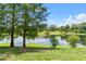 Picturesque lake view surrounded by mature trees and lush greenery, creating a serene and natural setting at 6384 Raleigh St # 2214, Orlando, FL 32835
