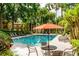 Community pool area with tables, chairs, and orange umbrella at 6384 Raleigh St # 2214, Orlando, FL 32835