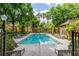 Community pool featuring well-maintained landscaping, trees, lounge chairs, and clear skies at 6384 Raleigh St # 2214, Orlando, FL 32835