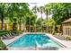 A lovely community pool area with lounge chairs and towering palm trees at 6384 Raleigh St # 2214, Orlando, FL 32835