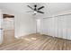 Bright bedroom features a ceiling fan, wood-look flooring and closet with folding doors at 643 Princewood Dr, Deland, FL 32724