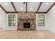 Close up view of the stone fireplace, flanked by windows allowing natural light at 643 Princewood Dr, Deland, FL 32724