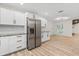 Spacious kitchen with stainless steel refrigerator and new cabinets that opens to a large living area at 643 Princewood Dr, Deland, FL 32724