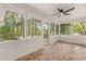 Relaxing screened porch with stone tile, ceiling fan, and views of the wooded backyard at 643 Princewood Dr, Deland, FL 32724