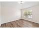 Cozy bedroom featuring hardwood floors and a bright window overlooking the neighborhood at 6484 S Goldenrod Rd # 41A, Orlando, FL 32822