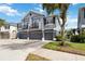 Stylish townhome featuring a gray exterior, multiple garage doors, and quaint second-story balconies with mature trees at 6484 S Goldenrod Rd # 41A, Orlando, FL 32822