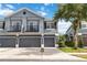 Stylish townhome featuring a gray exterior, multiple garage doors, and quaint second-story balconies at 6484 S Goldenrod Rd # 41A, Orlando, FL 32822