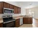 Open kitchen with stainless steel appliances and bar seating overlooks a bright living area at 6484 S Goldenrod Rd # 41A, Orlando, FL 32822
