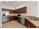 Well-equipped kitchen features stainless steel appliances, brown cabinetry, and tiled flooring at 6484 S Goldenrod Rd # 41A, Orlando, FL 32822