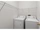Functional laundry room equipped with a washer, dryer, and wire shelving for storage at 6484 S Goldenrod Rd # 41A, Orlando, FL 32822