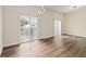 Bright living room with wood flooring, modern chandelier, and sliding glass doors to the balcony at 6484 S Goldenrod Rd # 41A, Orlando, FL 32822