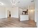 Open-concept living space with wood flooring, a modern chandelier, and seamless flow to the kitchen area at 6484 S Goldenrod Rd # 41A, Orlando, FL 32822