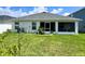 The rear of the house showcases a screened patio and lush green lawn at 7 Polermo Ave, St Cloud, FL 34771