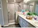 Bathroom features a glass shower door, vanity with dual sinks and grey tile walls at 7 Polermo Ave, St Cloud, FL 34771