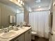 Bathroom with a double sink vanity, modern fixtures, and a shower with white tiled walls at 7 Polermo Ave, St Cloud, FL 34771