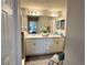 Bathroom features vanity with dual sinks, a large mirror and white cabinets at 7 Polermo Ave, St Cloud, FL 34771