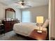 Bedroom with a large window, dresser with mirror, and a bed with white comforter at 7 Polermo Ave, St Cloud, FL 34771