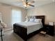Comfortable bedroom featuring a ceiling fan, window with sheer curtains, and a well-appointed bed at 7 Polermo Ave, St Cloud, FL 34771