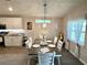 Light and bright dining room features a modern chandelier, natural light and seating for six at 7 Polermo Ave, St Cloud, FL 34771