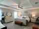 Comfortable main bedroom features neutral paint, a tray ceiling, a ceiling fan, and a king bed at 7 Polermo Ave, St Cloud, FL 34771