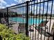 Community pool with lounge chairs and tables, fenced and landscaped at 7 Polermo Ave, St Cloud, FL 34771