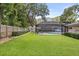 Expansive, well-maintained backyard with lush green lawn, privacy fence, and screened-in pool area at 708 Valencia Ct, Winter Garden, FL 34787