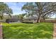 Large backyard with a well-kept lawn, mature trees, pool with enclosure, and fenced property line at 708 Valencia Ct, Winter Garden, FL 34787